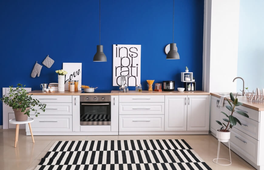 modern mutfakta lacivert duvar boyasi, beyaz mutfak dolaplari, ahsap tezgah