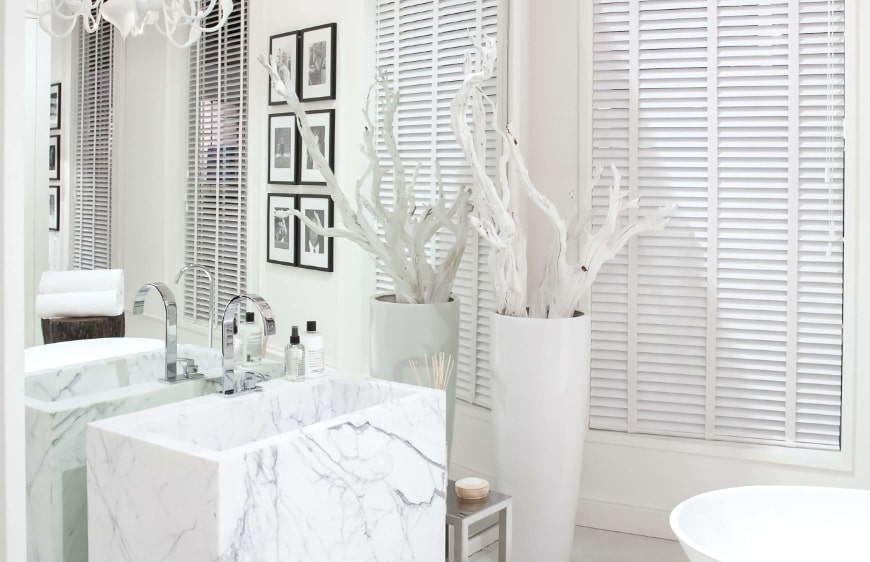 beyaz banyo tasariminda mermer yerden lavabo kullanimi, beyaz vazo ve aksesuarlar