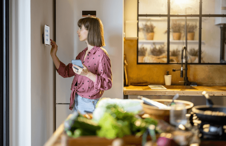 mutfakta duvarda asili dijital tablet kullanan kadin gorseli, evde akilli cihazlar ile kontrol, modern mutfak mekaninda sebzeler