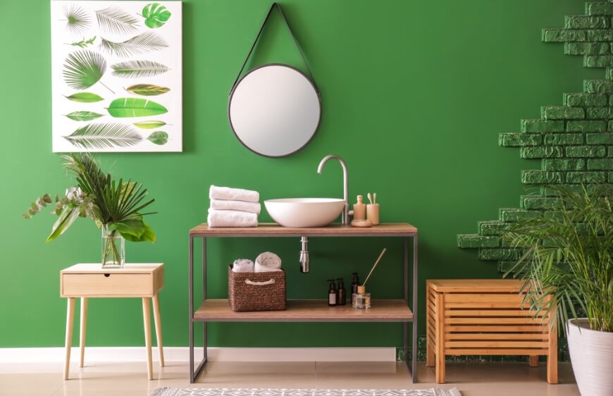 modern konforlu banyoda yesil duvar rengi ahsap tonlarda mutfak dolabi kirli sepeti 