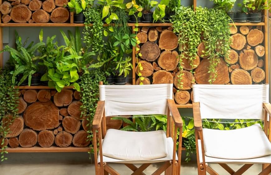 ahsap iskelet ve beyaz bez kumastan yonetmen sandalyesi, odun ve yesil yapraklardan duvar dekorasyonu