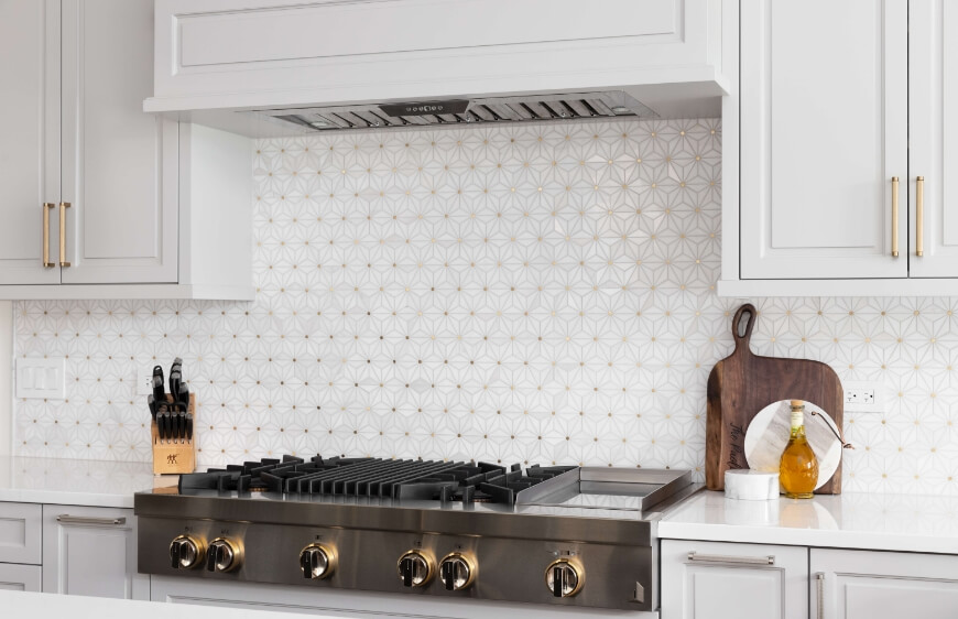 mutfakta paslanmaz celik luks firin ustu ocak, granit mutfak tezgahi, custom beyaz ve altin desenli seramik mutfak tezgah arasi 