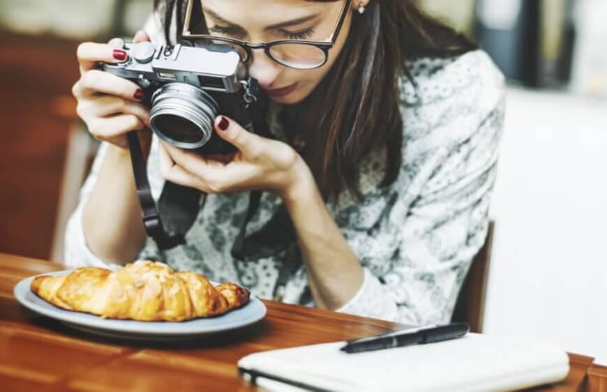 kamera ile yemek fotografi ceken kadin gorseli