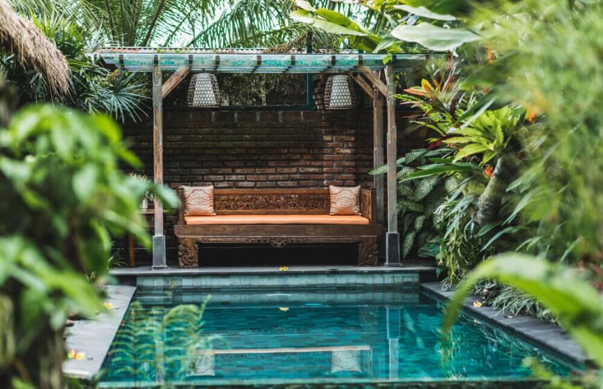 balide ormanda tasarim villada tropikal bitkiler icerisinde kucuk ve kisiye ozel yuzme havuzu, ahsap sofa 