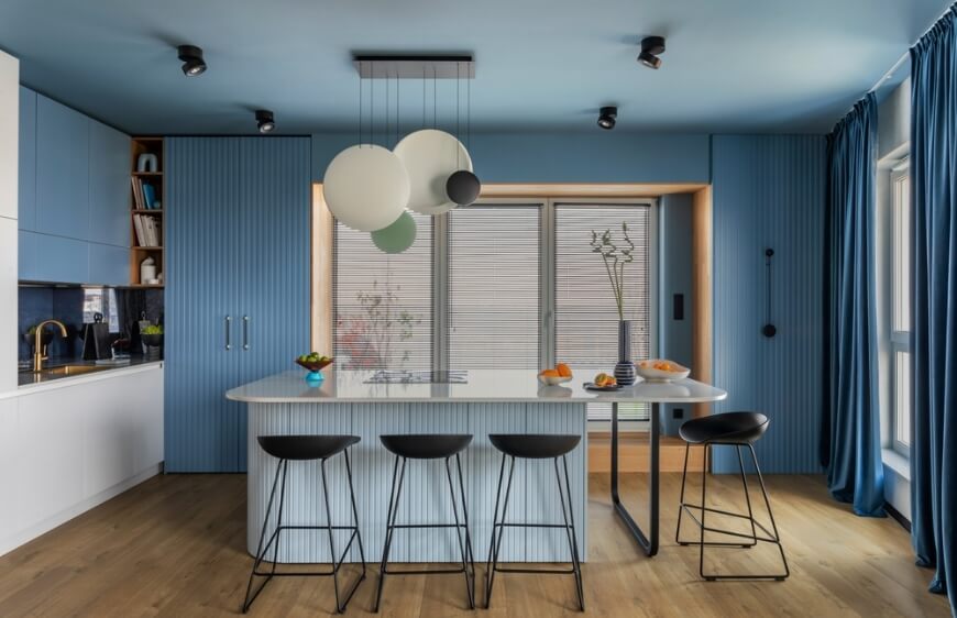 mermer adali mutfak alaninin modern tasarimi, ahsap duvar, mavi mutfak dolaplari, kuru cicekli vazo