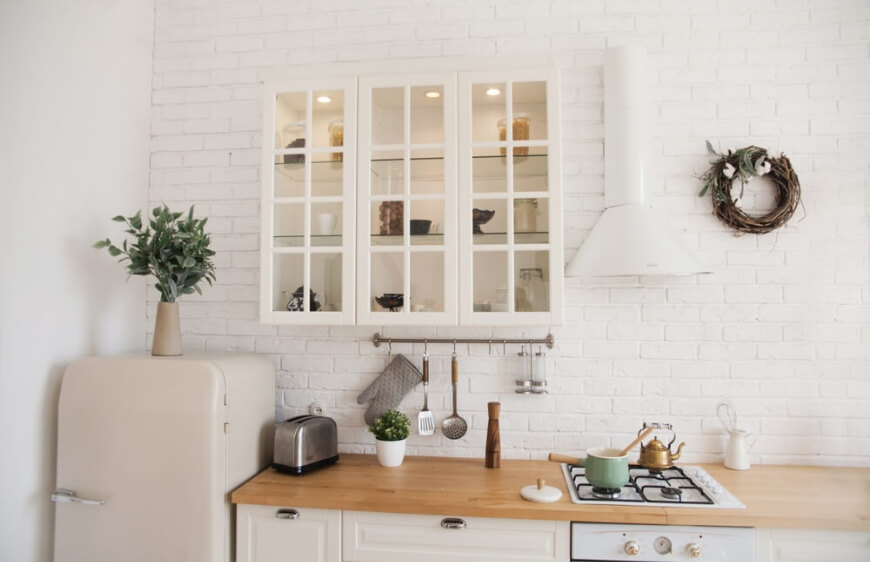 ham ahsap mutfak tezgahi beyaz camli pencereli isiklandirilmis dolaplar ve bitkiler ile dogal mutfak tasarimi